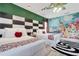 A colorful bedroom includes two beds, unique decorations, and a whimsical mural at 7564 Marker Ave, Kissimmee, FL 34747
