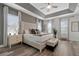 A spacious main bedroom features a decorative tray ceiling, a sitting area, and wood-look flooring at 7564 Marker Ave, Kissimmee, FL 34747