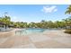 Relaxing community pool featuring lounge chairs, sun umbrellas, and lush landscaping, perfect for hot days at 7564 Marker Ave, Kissimmee, FL 34747