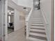 Welcoming entryway with staircase featuring neutral tile floors and natural light at 7564 Marker Ave, Kissimmee, FL 34747