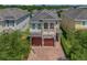 Charming two-story home featuring a stone facade, balcony, and a brick paved driveway leading to a two-car garage at 7564 Marker Ave, Kissimmee, FL 34747