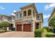 Charming two-story home showcasing a stone facade, a brick driveway, and a second story balcony at 7564 Marker Ave, Kissimmee, FL 34747