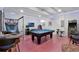 Spacious game room with a pool table, arcade games, and bright red flooring for endless fun at 7564 Marker Ave, Kissimmee, FL 34747