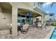 Covered patio with an outdoor kitchen, dining area, and a view of the pool for year-round enjoyment at 7564 Marker Ave, Kissimmee, FL 34747
