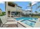 Resort-style pool area with a jacuzzi, lounge chairs, and a lush tropical backdrop perfect for relaxation at 7564 Marker Ave, Kissimmee, FL 34747
