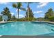 Inviting pool with a jacuzzi, basketball hoop, surrounded by lush landscaping and clear blue skies at 7564 Marker Ave, Kissimmee, FL 34747