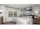 Bright bedroom featuring a comfortable queen-size bed, stylish decor, and a large window at 7751 Waterscape Dr, Groveland, FL 34736