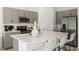 Contemporary kitchen features stainless steel appliances, gray cabinets, and island with breakfast bar at 7751 Waterscape Dr, Groveland, FL 34736