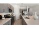 Modern kitchen features stainless steel appliances, gray cabinetry, an island with a sink, and lots of counter space at 7757 Waterscape Dr, Groveland, FL 34736