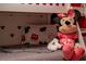 Close-up detail of a Mickey Mouse themed bedroom featuring a cute Minnie Mouse plush doll at 7905 Golden Pond Cir, Kissimmee, FL 34747