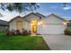 Beautiful single-story home featuring a well-maintained lawn, two car garage, and inviting entrance at 7905 Golden Pond Cir, Kissimmee, FL 34747