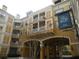 Exterior shot of a multi-story tan building with balconies and covered parking at Park North at Cheney Place at 860 N Orange Ave # 428, Orlando, FL 32801