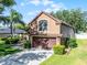 Two-story home with a tan stucco exterior, brown trim, attached two-car garage, and landscaped front yard at 1007 Golf View Estates Dr, Orange City, FL 32763