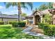Beautifully landscaped front yard with green grass, mature palm tree, manicured bushes, and a paved walkway at 1007 Golf View Estates Dr, Orange City, FL 32763