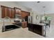 Spacious kitchen with dark wood cabinets, stainless steel appliances, and a functional center island at 1007 Golf View Estates Dr, Orange City, FL 32763