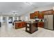 Open kitchen featuring dark cabinets, stainless appliances, center island, and easy access to the living area at 1007 Golf View Estates Dr, Orange City, FL 32763