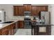 Modern kitchen features stainless steel appliances, granite countertops, and wood cabinets at 1007 Golf View Estates Dr, Orange City, FL 32763