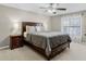 Comfortable main bedroom features a ceiling fan, a dark wood bed frame, and side tables with lamps at 1007 Golf View Estates Dr, Orange City, FL 32763