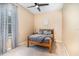 Cozy bedroom with a ceiling fan, plush carpet, and natural light from the window with patterned curtains at 10222 Marsh Pine Cir, Orlando, FL 32832