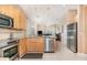 Bright kitchen featuring stainless steel appliances, tile floors, and granite countertops with an open concept layout at 10222 Marsh Pine Cir, Orlando, FL 32832