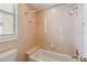 This bathroom has tiled walls, a bathtub with shower, a window and a toilet at 1024 Featherstone Cir, Ocoee, FL 34761