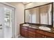 This bathroom has a double vanity with a granite countertop and access to the outdoor patio at 1024 Featherstone Cir, Ocoee, FL 34761