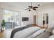 Staged bedroom with wood floors, ceiling fan, access to patio, and ensuite bathroom at 1024 Featherstone Cir, Ocoee, FL 34761