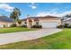 Inviting one-story home with a two-car garage, arched windows, and a well-manicured lawn at 1024 Featherstone Cir, Ocoee, FL 34761