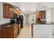 Kitchen with wood cabinets, granite countertops, and black appliances, seamlessly connecting to other rooms at 1024 Featherstone Cir, Ocoee, FL 34761
