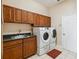 Functional laundry room with overhead cabinets, sink, and modern washer and dryer at 1024 Featherstone Cir, Ocoee, FL 34761