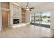 Open living room with fireplace, built-in shelves, ceiling fan, tile floors, and sliding glass doors to pool at 1024 Featherstone Cir, Ocoee, FL 34761