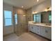 Bathroom featuring double sinks, a walk-in shower, tiled floors, and modern lighting fixtures at 1043 Gloryland Ct, Sanford, FL 32771