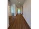 A long hallway with wood flooring leads to a bright, open space, freshly painted and ready for personal touches at 1043 Gloryland Ct, Sanford, FL 32771