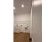 Bright laundry room with white cabinets, sink, wire shelving, and wood-look flooring at 1043 Gloryland Ct, Sanford, FL 32771
