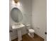 Modern powder room with pedestal sink, round mirror, and neutral wall color at 1043 Gloryland Ct, Sanford, FL 32771