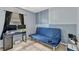 Bedroom featuring blue futon, black desk with monitors, and light tile flooring at 108 Orion Way, Sanford, FL 32773
