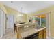 Open kitchen featuring granite countertops, bar seating, and stainless steel sink overlooking the dining area at 108 Orion Way, Sanford, FL 32773