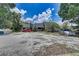Exterior view of a single-story home on a large lot with multiple cars parked in the front driveway at 11624 Delmar Ave, Orlando, FL 32836