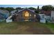 Aerial view of the backyard featuring a screened-in pool, manicured lawn, and fenced perimeter at dusk at 12543 Waterhaven Cir, Orlando, FL 32828
