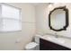 Bathroom featuring vanity with a dark wood cabinet, a mirror, and a window at 12543 Waterhaven Cir, Orlando, FL 32828
