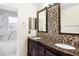 Bathroom with double vanity, granite countertops, tiled backsplash, and marble tiled bath/shower at 12543 Waterhaven Cir, Orlando, FL 32828