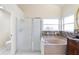 Bright bathroom featuring a large tub, glass shower, and decorative tile accents at 12543 Waterhaven Cir, Orlando, FL 32828