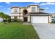 Two-story home featuring a well-manicured lawn, a two-car garage, and a neutral-colored facade at 12543 Waterhaven Cir, Orlando, FL 32828