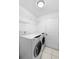 Functional laundry room with modern appliances, tiled floors, and built-in shelving at 12543 Waterhaven Cir, Orlando, FL 32828