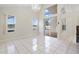 Open-concept living room featuring tile floors, large windows with lake views, and access to the pool area at 12543 Waterhaven Cir, Orlando, FL 32828