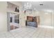 Open-concept living room featuring tile floors, a mosaic wet-bar, and an elegant chandelier at 12543 Waterhaven Cir, Orlando, FL 32828