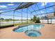 Beautiful screened-in pool with a spa and pond views creates a private retreat for outdoor relaxation and enjoyment at 12543 Waterhaven Cir, Orlando, FL 32828