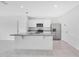 Modern kitchen with white cabinets, granite countertops, a stainless steel fridge, and an island at 1312 Sugarwood St, Davenport, FL 33837
