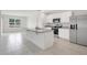 Modern kitchen with white cabinets, granite countertops, a stainless steel fridge, and an island at 1312 Sugarwood St, Davenport, FL 33837