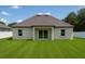 A view of the back exterior showing a well maintained lawn and covered patio at 13254 Sw 30Th Terrace Rd, Ocala, FL 34473